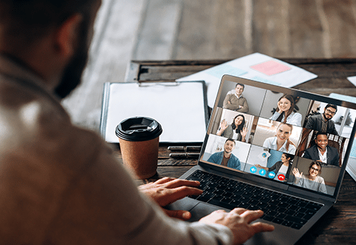 App for communication with employees. Online video conference. Young bearded man communicates via video call with business partners, he sits at the creative modern office space