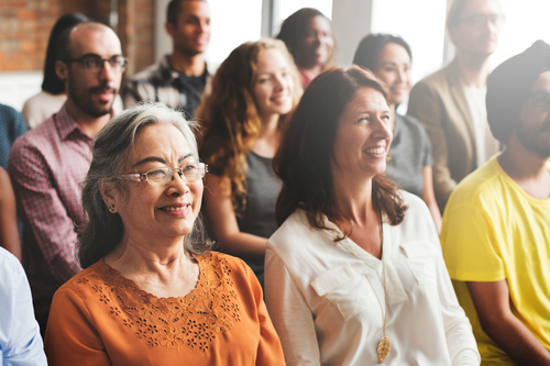 Diverse Group of people in bright room, smiling.