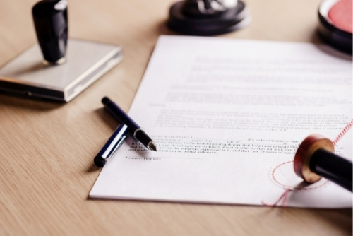 Notarized document on desk with stamp and pen sitting next to it