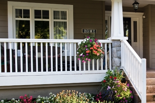 Front porch of home with colorful flowers and front steps leading to door